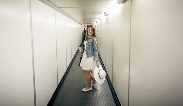 Mujer con bolsas caminando en la puerta de embarque en el aeropuerto — Foto de Stock