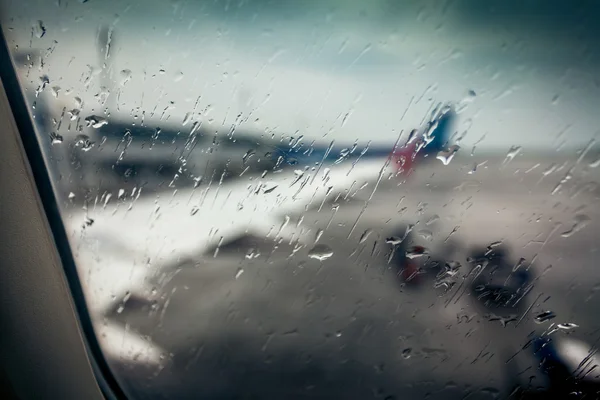 Vliegtuig vleugel door passagier raam met regen druppels — Stockfoto