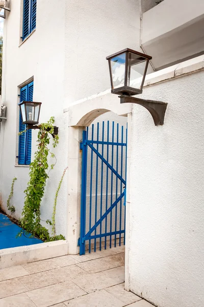 Puertas azules en pared blanca con lámpara de gas al estilo griego —  Fotos de Stock