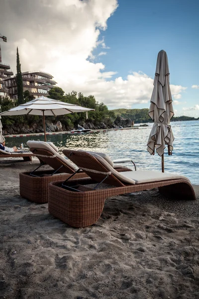 Vue de deux chaises longues en bois avec parasols sur la plage de la mer — Photo