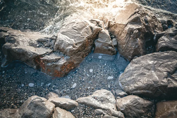 灰色的岩石在海上岸在日落时分 — 图库照片