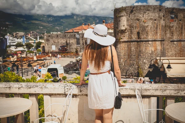 Photo of beautiful woman wearing hat looking at old city — Stock Photo, Image