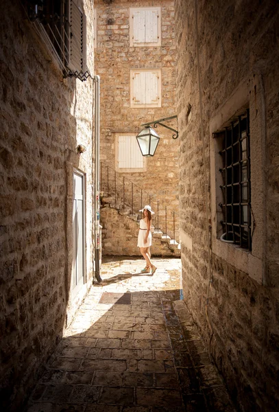 Young woman posing on old narrow street at sunny day — Stock Photo, Image