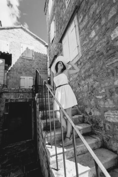 Monokrom foto af ung kvinde gå ned ad verandaen - Stock-foto