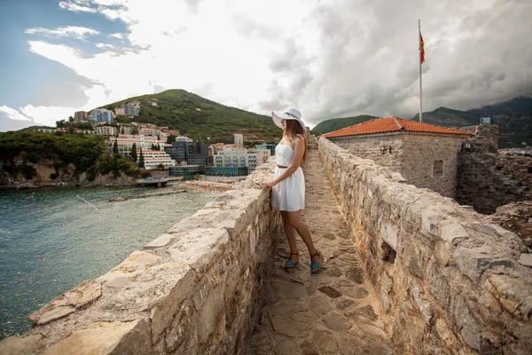 Mujer joven caminando en la parte superior de la pared de piedra en el viejo castillo —  Fotos de Stock