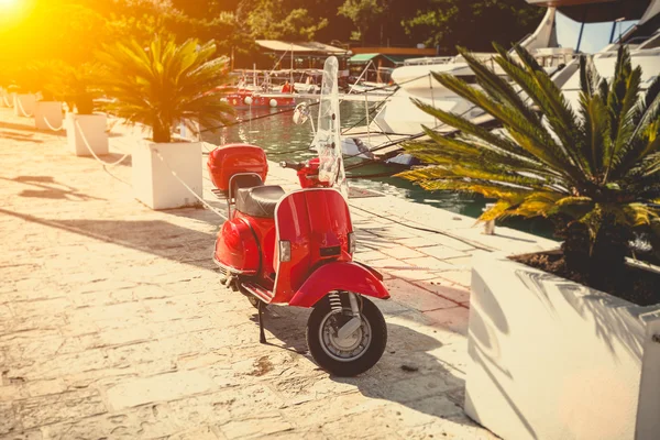 Foto van vintage rode scooter geparkeerd op straat op zonnige dag — Stockfoto