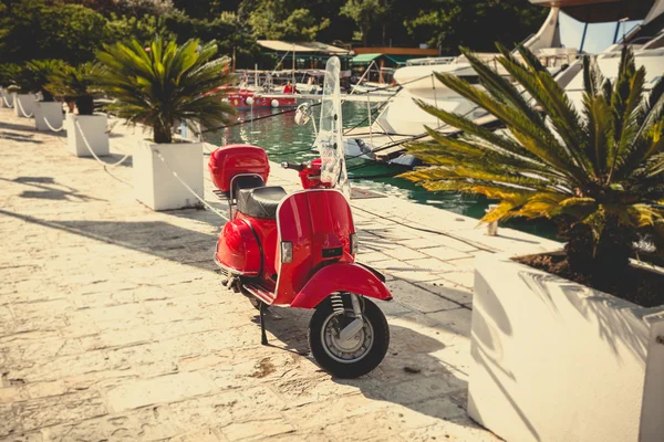 Afgezwakt foto van retro rode scooter geparkeerd in de haven — Stockfoto