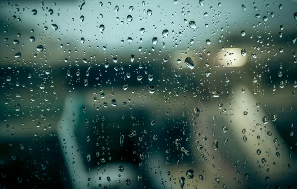 Niewyraźne budynku przez okno z deszczu — Zdjęcie stockowe