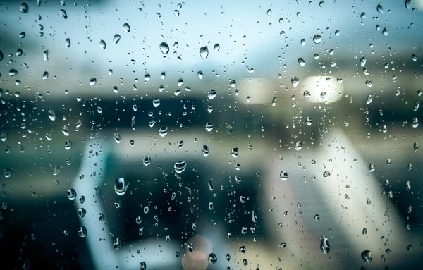 Natte straat op regenachtige dag door raam met water druppels — Stockfoto