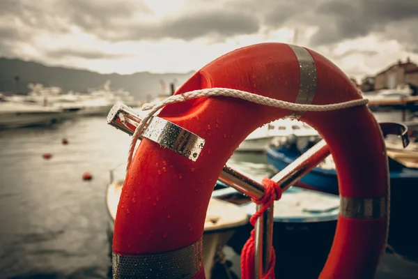 Toned photo of lifebuoy at rainy weather in seaport — Stock Photo, Image