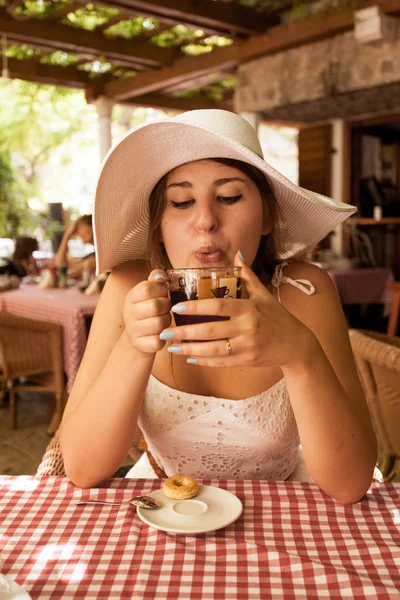 Elegant kvinna dricker varmt te till frukost på café — Stockfoto