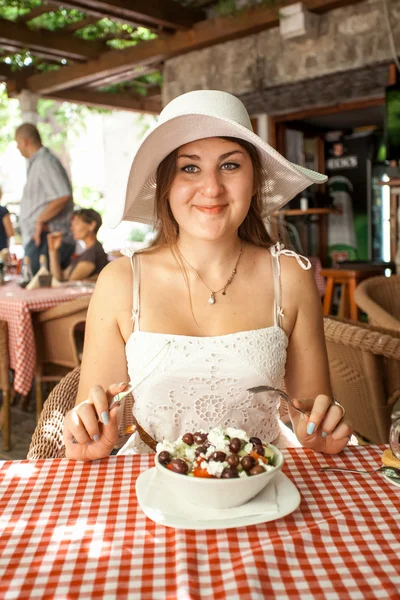 Portret van lachende vrouw salade eten in restaurant — Stockfoto