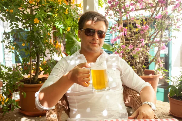 Portret przystojny mężczyzna pije piwo w restauracji w upalny dzień — Zdjęcie stockowe