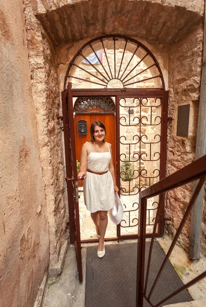 Young woman walking in old forged gates and narrow street — Stock Photo, Image