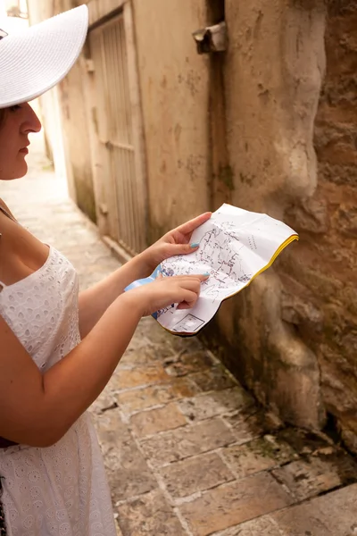 woman lost in old city pointing at map