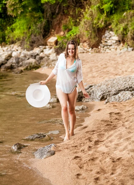 Femeie zâmbitoare în cămașă albă mergând pe plajă cu nisip — Fotografie, imagine de stoc