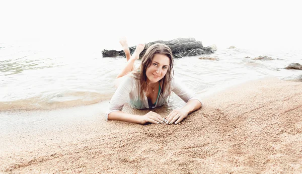 Bella donna sorridente rilassante sulle onde del mare sulla spiaggia di sabbia — Foto Stock