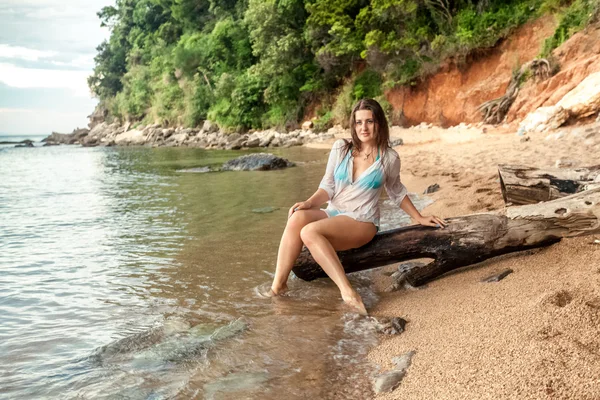 Mulher sexy sentado em grande ramo na costa do mar — Fotografia de Stock