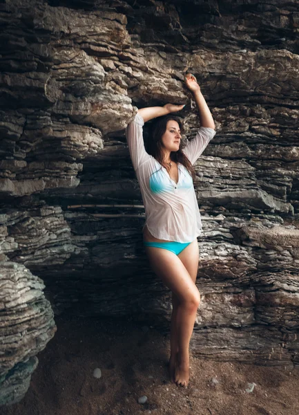 Kadın ıslak Beyaz gömlekli yüksek cliff Beach karşı yaslanmış — Stok fotoğraf