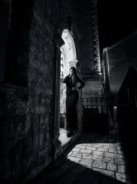 Monochrome night photo of sexy woman posing at old arch — Stock Photo, Image