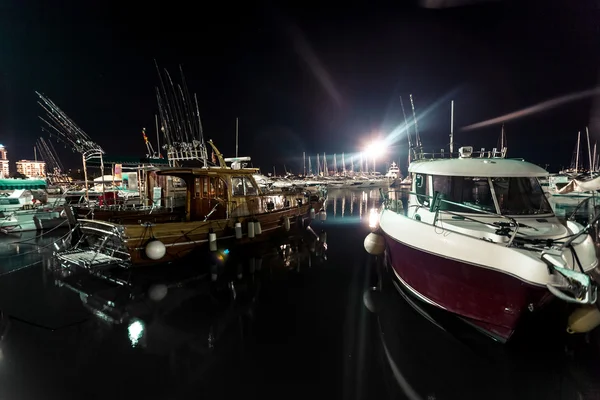 Night shot of wooden and motorboats moored at sea port — Stock Photo, Image