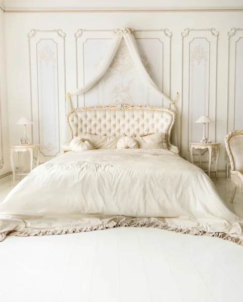 Luxuriöse weiße Innenausstattung mit klassischem Bett — Stockfoto
