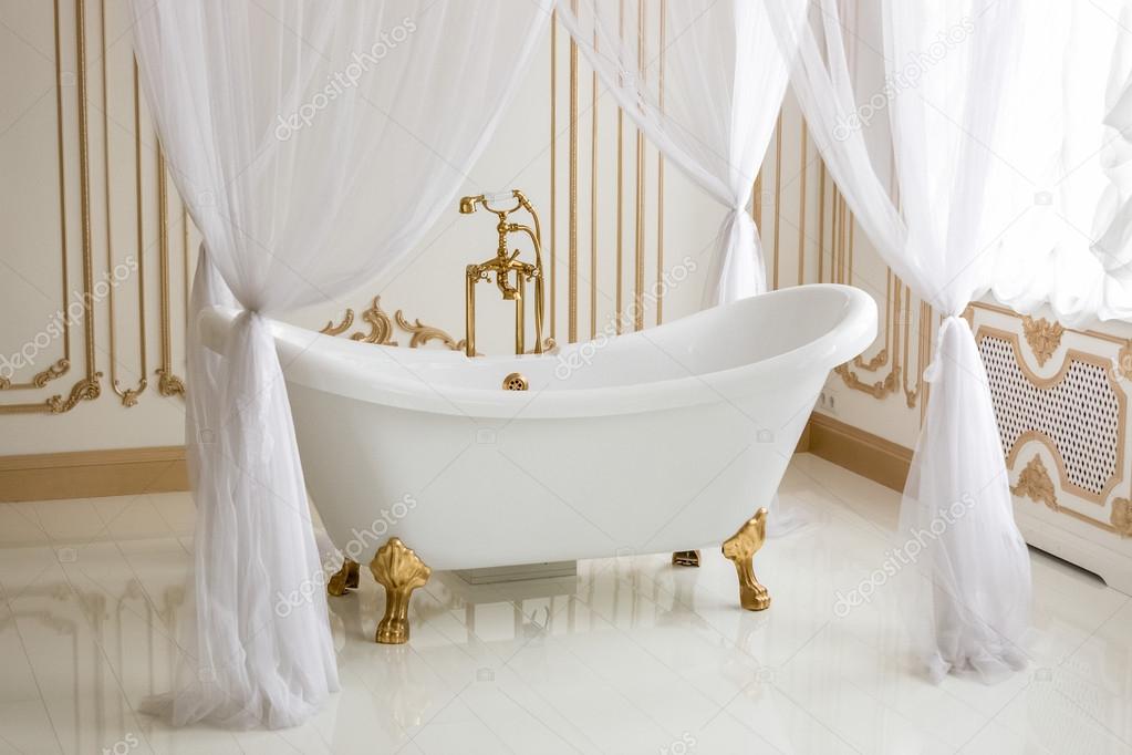white luxurious bath with golden legs at bathroom