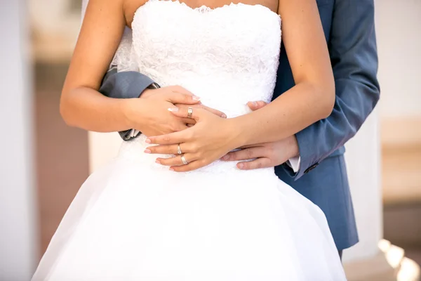 Foto di sposo che abbraccia sottile giovane sposa da dietro — Foto Stock