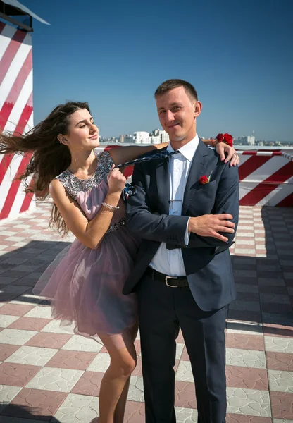 Sexy girl hugging boyfriend on roof top at windy day — Stock Photo, Image