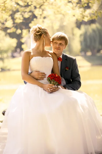 Retrato tonificado de novia y novio abrazándose en la orilla del río —  Fotos de Stock