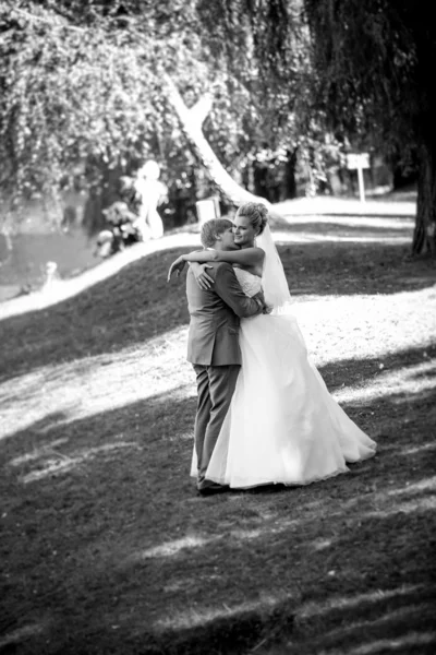 Mariée heureuse et marié étreignant au parc à la journée ensoleillée — Photo