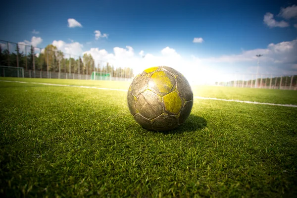 Soccer football on grass field at sun beams — Stock Photo, Image