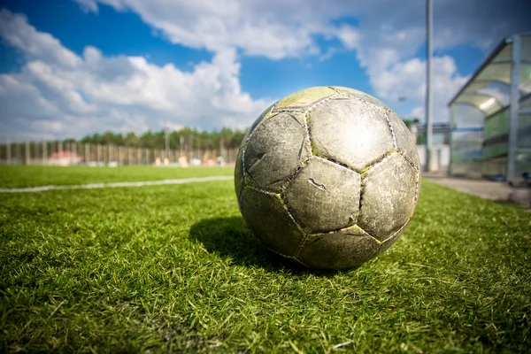 Alter Fußball auf dem Rasenplatz bei sonnigem Tag — Stockfoto