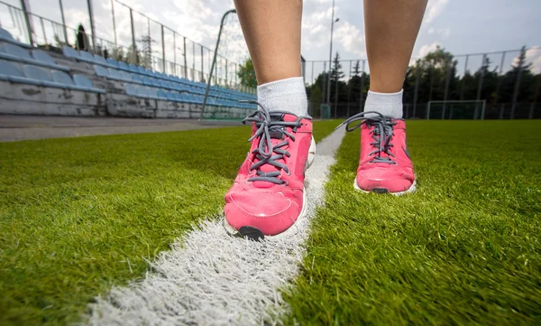 Mulher em sapatilhas rosa correndo no campo de grama — Fotografia de Stock