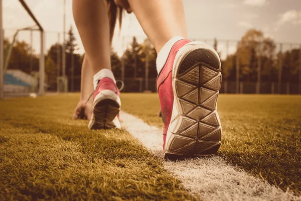 Toned photo of slim woman running on grass field