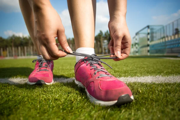 Young woman tying shoe laces before running — Stock Photo, Image