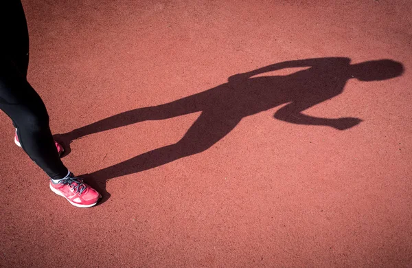 Photo of shadow of running woman on running track — Stock Photo, Image
