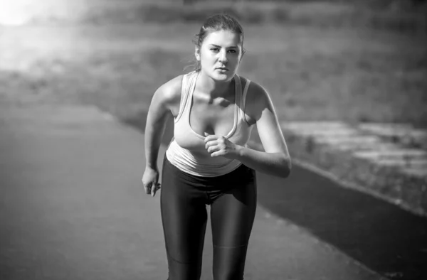 Beautiful slim woman running on stadium at sunny day — Stock Photo, Image