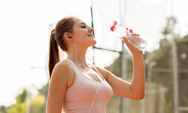 Gadis tersenyum minum air setelah berjalan di hari yang panas — Stok Foto