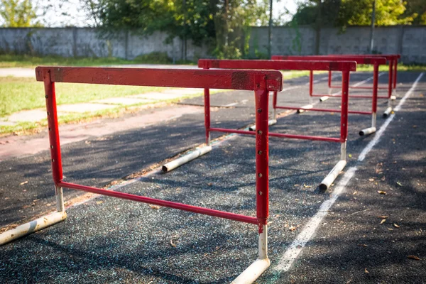Velhos obstáculos vermelhos para uma corrida de obstáculos no estádio abandonado — Fotografia de Stock