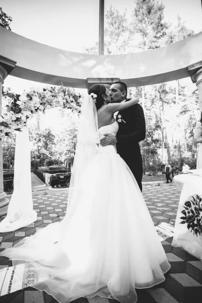 Monochromes Porträt glücklicher Braut und Bräutigam beim Küssen in der Nische — Stockfoto
