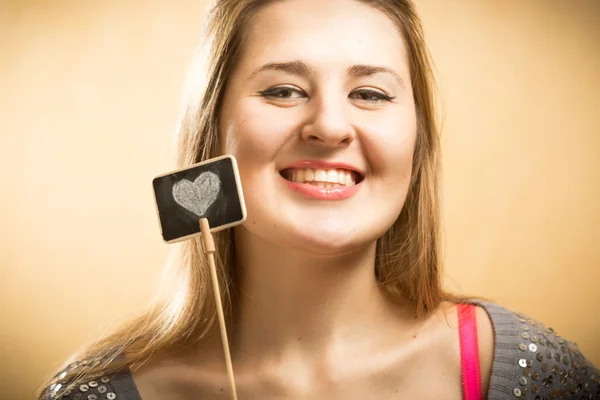 Gelukkig lachende vrouw met krijt bord met getekende hart — Stockfoto