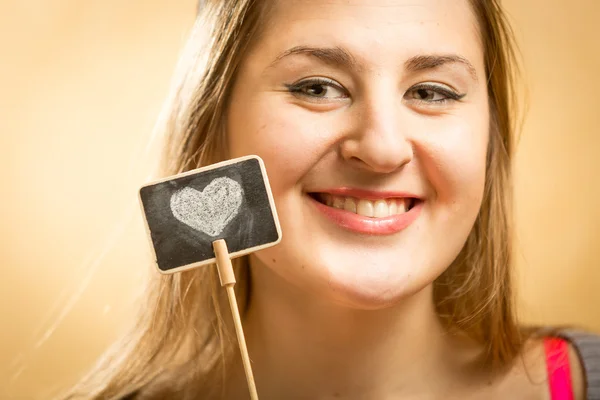 Mulher posando com pequeno quadro com coração desenhado — Fotografia de Stock