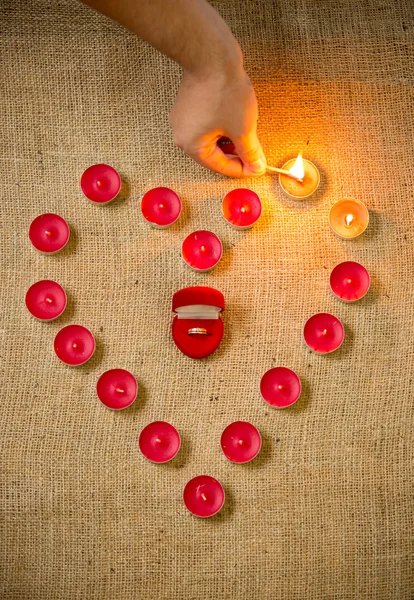 Foto de la persona encendiendo velas en forma de corazón — Foto de Stock