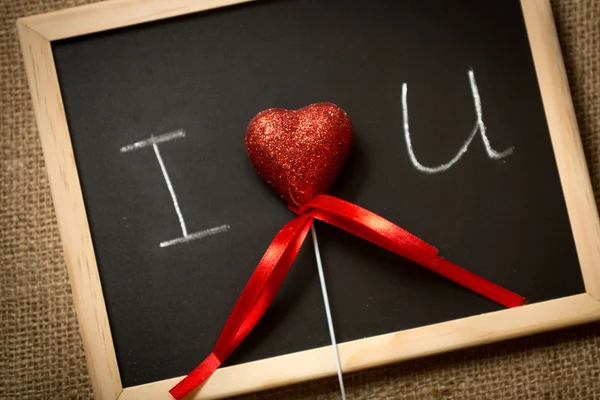 Rood hart liggen op blackboard met schriftelijke verklaring van de liefde — Stockfoto