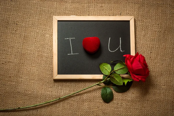 Foto av kärleksförklaring på blackboard med röd ros — Stockfoto