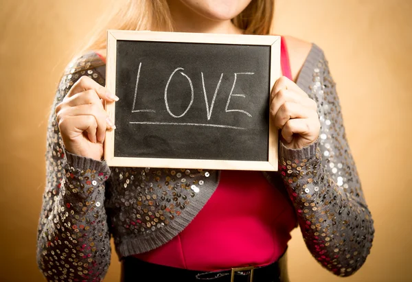 Beautiful woman holding board with word "Love" written by chalk — Stock Photo, Image