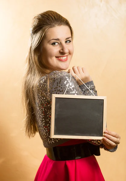 Sorrindo bonito mulher segurando pequeno quadro negro — Fotografia de Stock