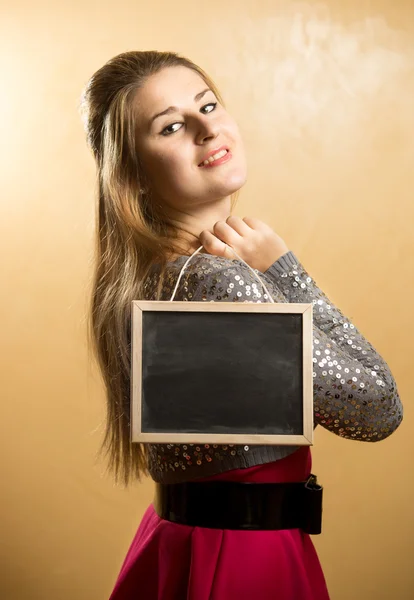 Femme mignonne posant avec tableau noir vierge — Photo