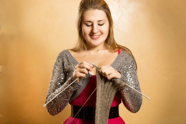 Lächelnde blonde Frau strickt Schal mit Nadeln — Stockfoto